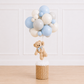 Luxury teddy bear balloon basket centerpiece featuring a plush teddy bear, woven wicker basket, and customizable organic balloon cluster for baby showers by Cedarwood Events.