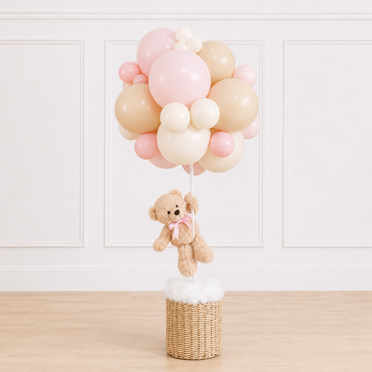 Luxury teddy bear balloon basket centerpiece featuring a plush teddy bear, woven wicker basket, and customizable organic balloon cluster for baby showers by Cedarwood Events.
