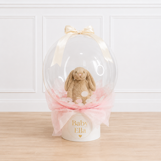 Welcome a little one with our personalized 24-inch Bubble Balloon featuring a plush bunny, custom keepsake hat box, and luxury styling by Cedarwood Events.